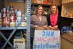 BHC staff members hold a food drive donation box in the pantry